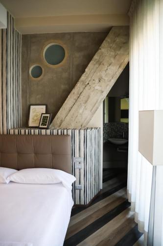 a bedroom with a bed and a wooden floor at Serendipity Rooms in Milan
