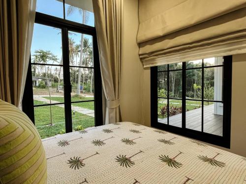 a bedroom with a bed and a window at Cococreek Kohkood in Ban Khlong Mat