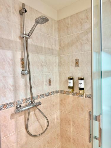 a shower with a shower head in a bathroom at Maison Bellebat - proche d'Orleans in Orléans