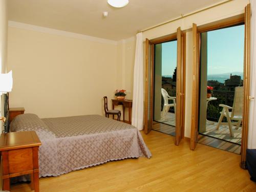 a hotel room with a bed and a balcony at Hotel Belvedere in Torri del Benaco