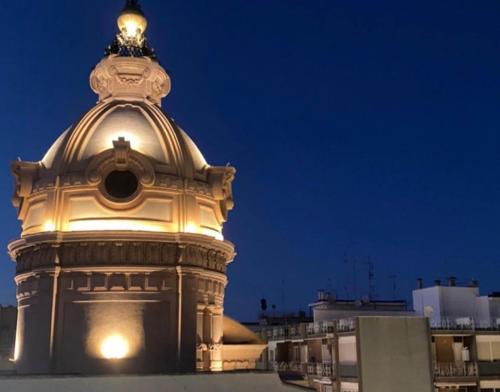 a building with a clock tower at night at Primo Piano in Sparano in Bari