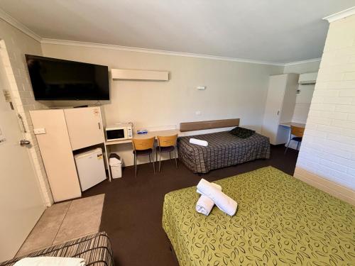 a hotel room with two beds and a flat screen tv at Ashwood Motel in Gosford