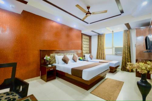 a hotel room with two beds and a window at Hotel Shivdev International, near New Delhi Railway Station & City Centre in New Delhi