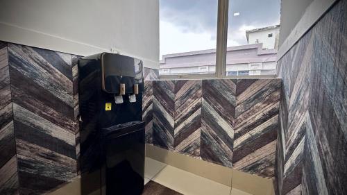 a room with a drink dispenser on the wall at Swing & Pillows - Sentul Titiwangsa in Kuala Lumpur