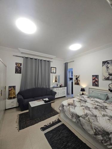 a living room with a bed and a couch at Studio towam hospital 2 in Al Ain