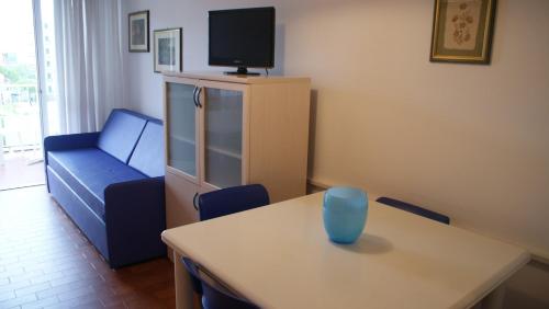 ein Wohnzimmer mit einem Tisch und einem blauen Sofa in der Unterkunft Studio in Lido di Jesolo 24796 in Lido di Jesolo
