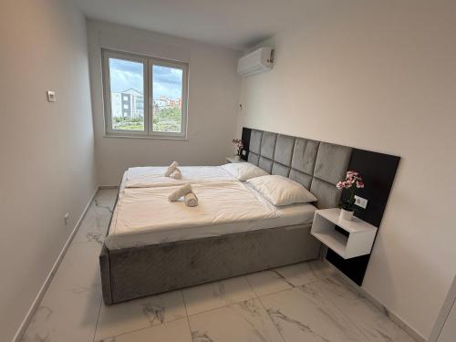 a bedroom with a large bed with a window at Astrid Deluxe in Novalja