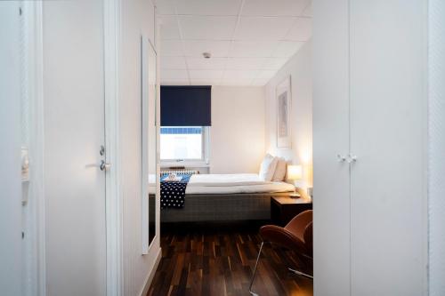 ein kleines Zimmer mit einem Bett und einem Fenster in der Unterkunft Port Hotel in Karlshamn