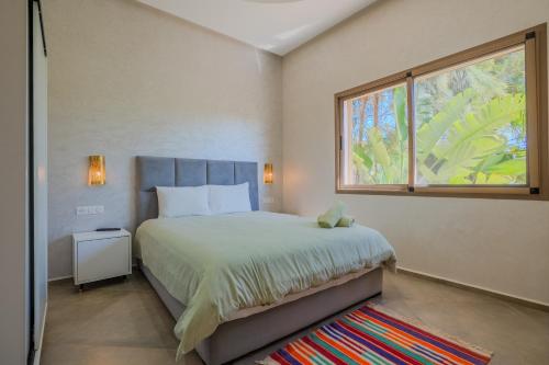 a bedroom with a large bed and a window at Villa moderne à 5 min de la plage avec jardin et 3 salons in Essaouira