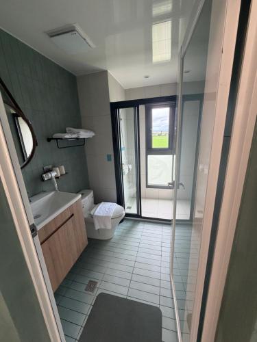 a bathroom with a shower and a toilet and a sink at MM No6 Villa in Luodong