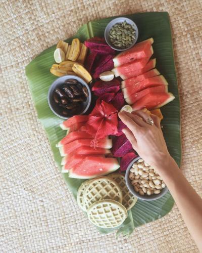 a plate of food with fruits and nuts on a table at Betelnut Eco-Lodge Sumba in Lambatama