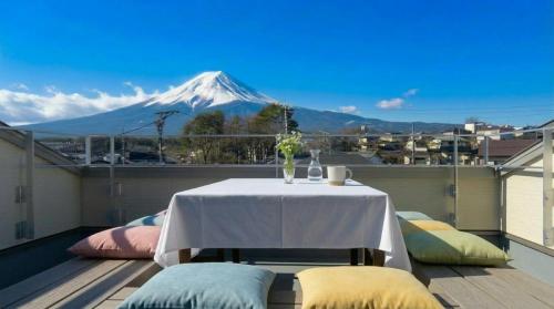 a table on a balcony with a mountain in the background at Villa Fuji-nishiki in Fujikawaguchiko