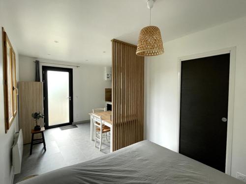 a bedroom with a bed with a black door and a table at Studio au calme - rez de jardin in Chignin