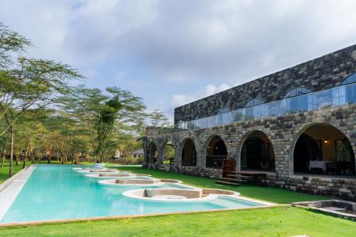 a swimming pool in front of a building at Giraffe Manor Tanzania in Usa