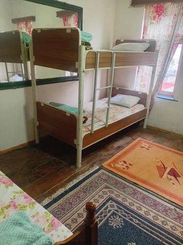 a room with two bunk beds and a rug at Business Hostel in Korçë
