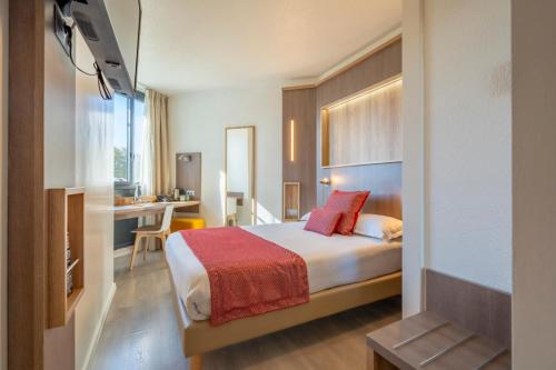 a hotel room with a bed and a desk at Hôtel Le Bayonne in Bayonne
