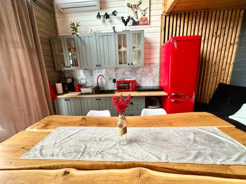 a kitchen with a wooden table with a red refrigerator at Czerwona Stodoła Karkonoska in Podgórzyn