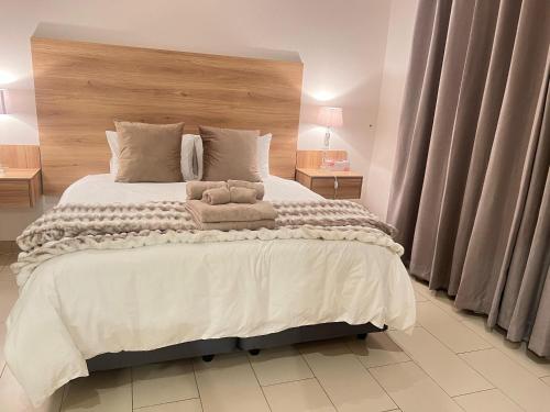 a bedroom with a large bed with two stuffed animals on it at Valley Croft Farm in Hekpoort