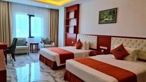 a hotel room with two beds and a desk at Lan Chau Luxury Hotel in Cửa Lô