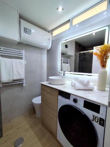 a bathroom with a sink and a washing machine at Blue Piscis Studio - Piscina in Benalmádena