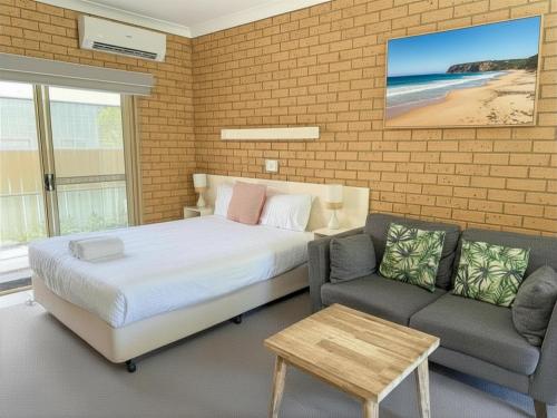 a bedroom with a bed and a couch at Yamba Motor Inn in Yamba