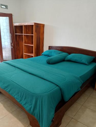 a bed with blue sheets and pillows in a bedroom at Tetebatu Fullmoon in Tetebatu