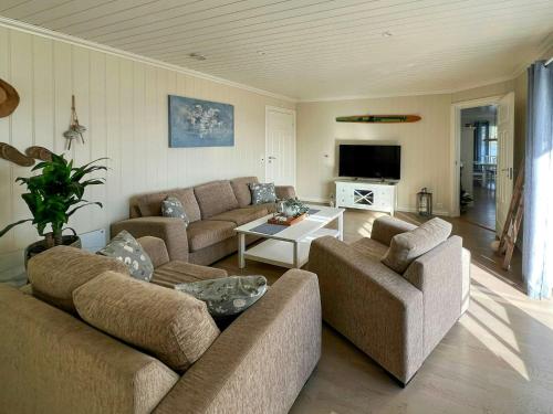 a living room with two couches and a table at Cottage With Private Dock By Eidangerfjord in Porsgrunn