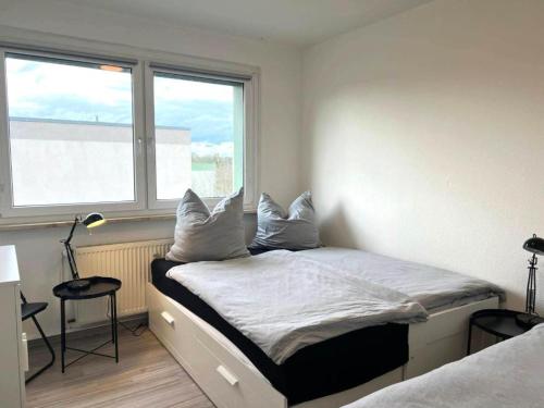 a bedroom with a bed with white sheets and pillows at Ferien- & Monteurwohnung, 5 Betten, WLAN, Parkplatz, Balkon in Nonnendorf
