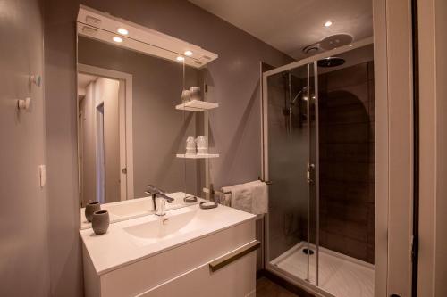 a bathroom with a sink and a shower at Hôtel des Récollets in Sarlat-la-Canéda