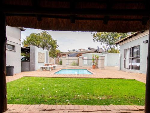 a house with a swimming pool in a yard at Andela Guesthouse in Bloemfontein