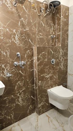 a bathroom with a shower with a toilet and a sink at Cherry Blossom in Varanasi