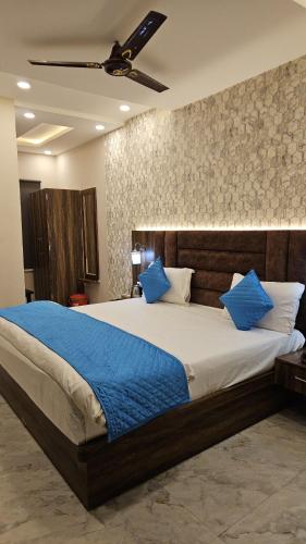 a bedroom with a large bed with blue pillows at Cherry Blossom in Varanasi