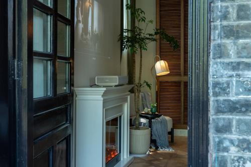 a living room with a fireplace and a door at La MAISON Banshan in Chongqing