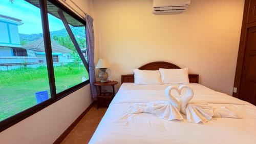 a bedroom with a bed with a heart on it at Kamala Garden Bungalows in Kamala Beach