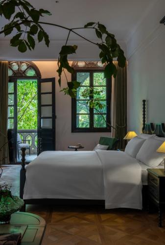 a bedroom with a large white bed and two windows at La MAISON Banshan in Chongqing