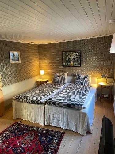 una camera d'albergo con due letti e due lampade di One Room Bed & Breakfast a Skänninge