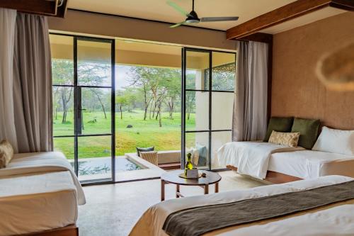a bedroom with two beds and a large window at Giraffe Manor Tanzania in Usa
