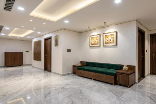 a living room with a green couch in a room at Hotel Savera Amritsar Near Golden Temple in Amritsar