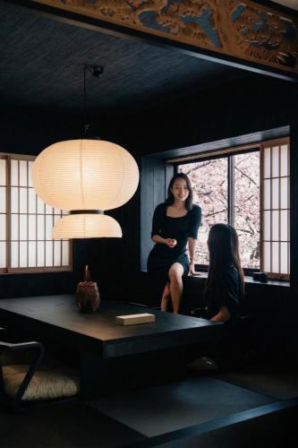 a woman sitting on a table in a room at ERA1220 Shinjuku,3bedroom,8people in Tokyo