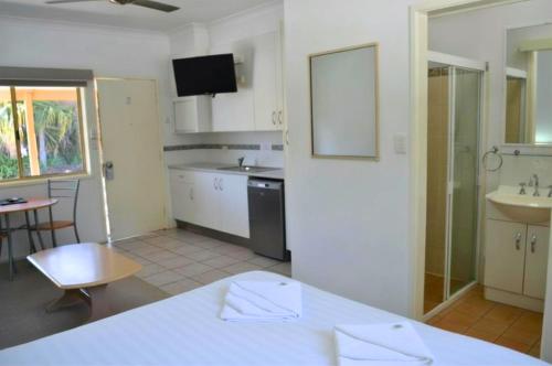 a kitchen with a table and a sink and a counter at Yamba Motor Inn in Yamba