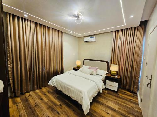 a bedroom with a large bed and curtains at Luxe Flat Light in Mama