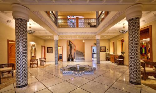 a large lobby with columns and a table in the middle at Palais Amador in Oulad Mazoug