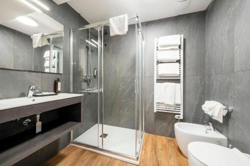 a bathroom with a shower and a toilet and a sink at Nord Hotel in Cortina dʼAmpezzo