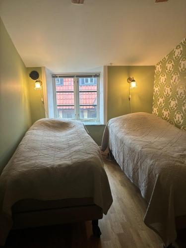 a bedroom with two beds and a window at Fiskargränden, Landskrona in Landskrona