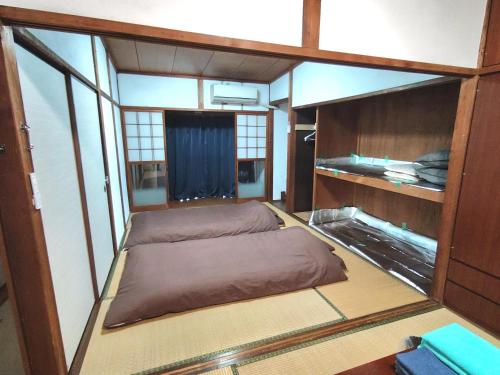 a small room with a bed in the middle at OZigaoka Guest House in Otsu