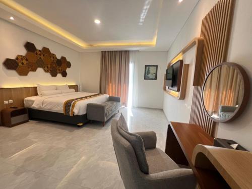 a hotel room with a bed and a television at Front One The Andia Boyolali in Boyolali