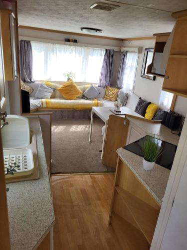 a kitchen and a living room in a rv at Caravan in Chapel Skegness in Chapel Saint Leonards