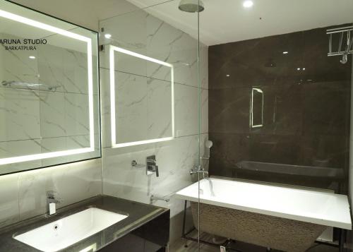 a bathroom with a sink and a mirror and a tub at Hotel Shubham Prestige RC Puram in Lingampalli