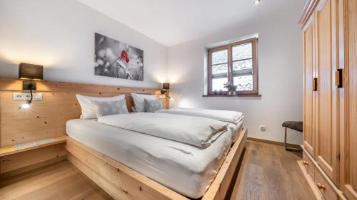 a bedroom with a large bed with a wooden wall at Mountain Lodge in Lenggries
