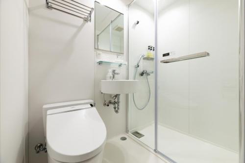 a bathroom with a shower and a toilet and a sink at Hotel Sekumiya in Obama